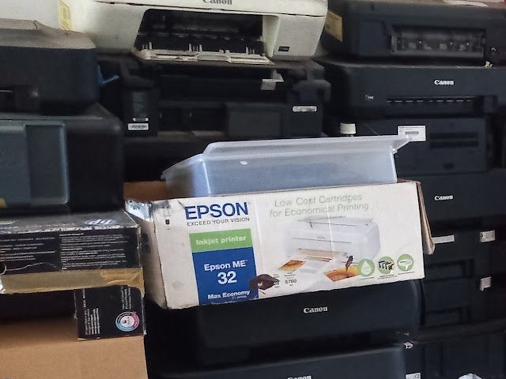 Tumpukan printer dan elektronik bekas di gudang